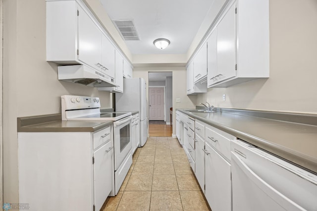 kitchen featuring sink, white appliances, light tile patterned floors, and white cabinets