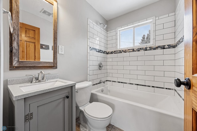 full bathroom featuring toilet, tiled shower / bath, and vanity