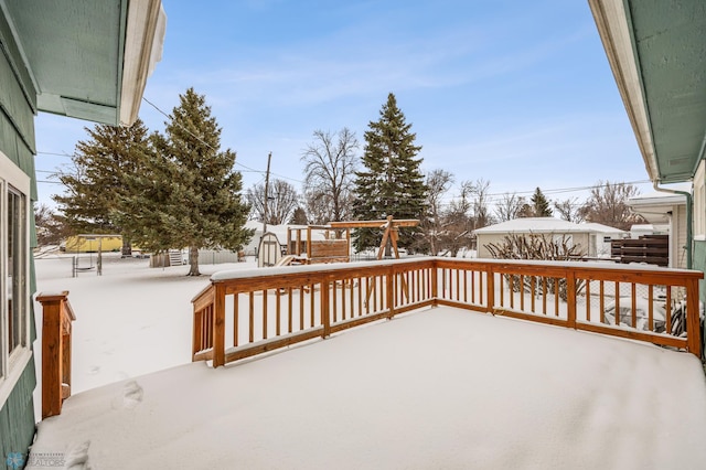 snow covered deck with a storage shed