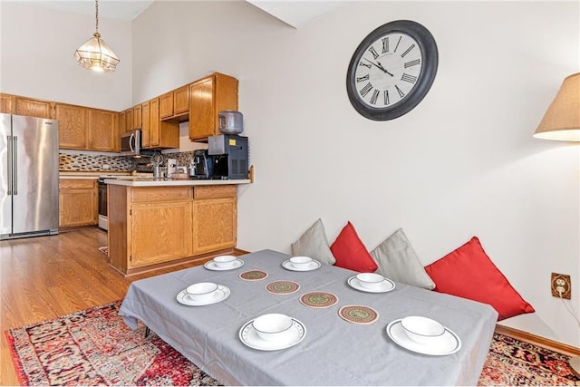 dining space featuring a towering ceiling and hardwood / wood-style flooring