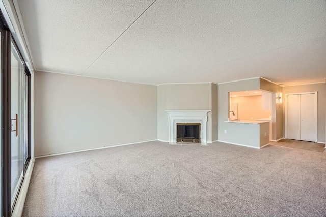 unfurnished living room featuring a textured ceiling, ornamental molding, and light colored carpet