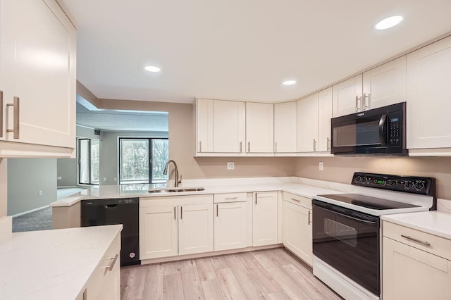 kitchen featuring black appliances, light hardwood / wood-style floors, light stone counters, white cabinets, and sink