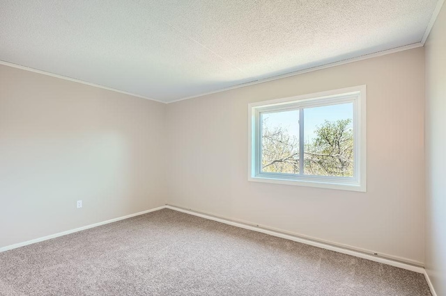 empty room featuring a textured ceiling, ornamental molding, and carpet floors