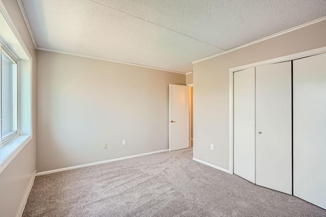 unfurnished bedroom with light colored carpet, ornamental molding, a textured ceiling, and multiple windows