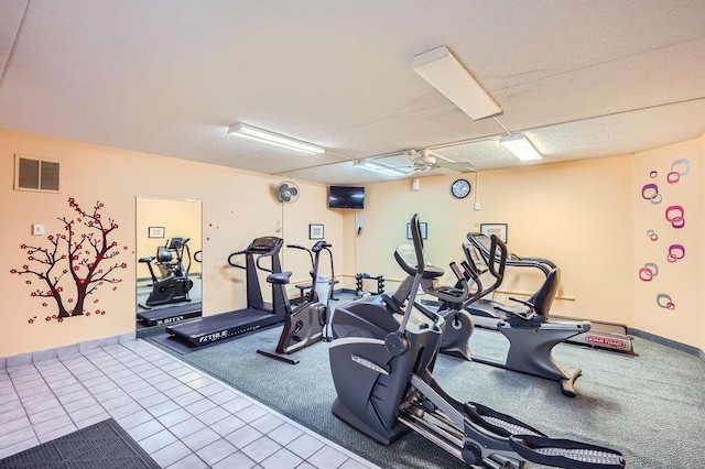 workout area with a textured ceiling, ceiling fan, and carpet