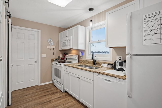 kitchen with sink, white cabinets, hanging light fixtures, and white appliances