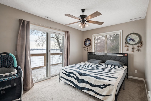 carpeted bedroom with a textured ceiling, ceiling fan, access to outside, and multiple windows