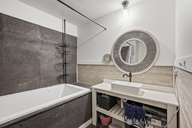 bathroom featuring tiled bath and vanity