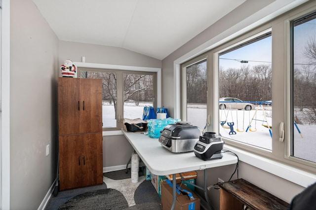 carpeted office with a healthy amount of sunlight and vaulted ceiling