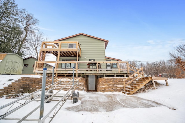 snow covered property featuring a storage unit and a deck