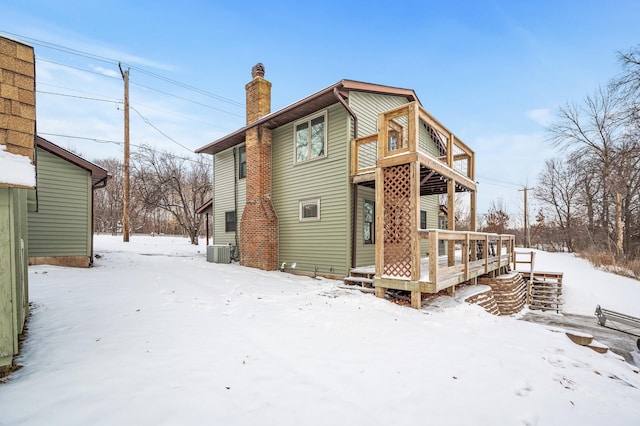 snow covered property featuring a wooden deck and cooling unit