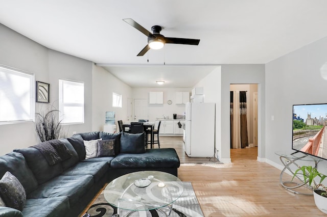 living room with light hardwood / wood-style floors and ceiling fan