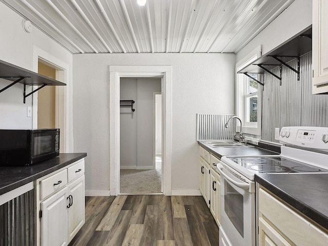 kitchen featuring white range with electric cooktop, dark hardwood / wood-style floors, white cabinetry, and sink