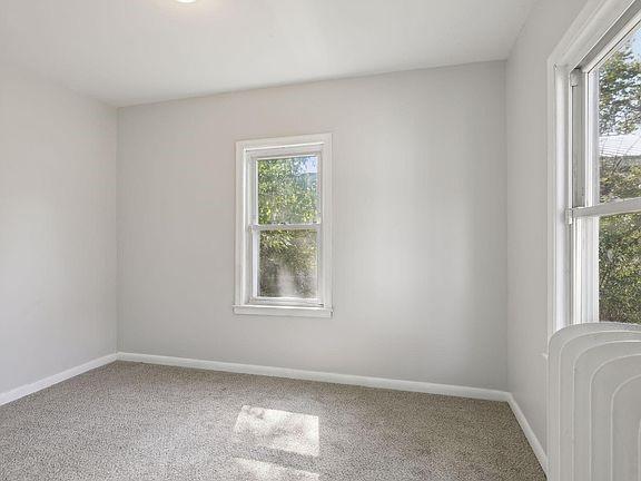 carpeted empty room featuring radiator