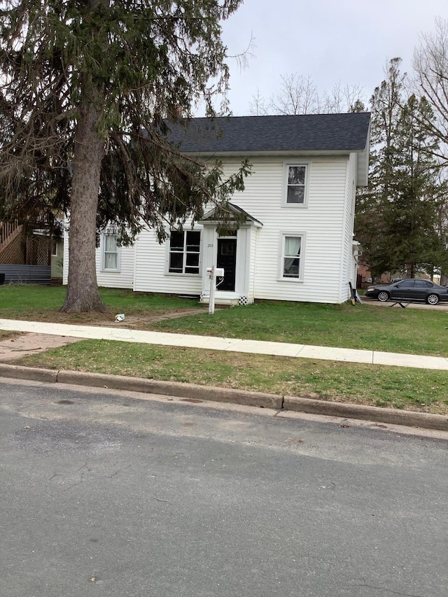 203 4th St, River Falls, WI 54022 - view of front facade with a shingled roof and a front lawn