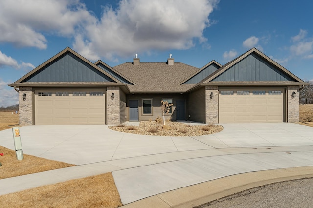 view of front of house featuring a garage, driveway, brick siding, and a chimney