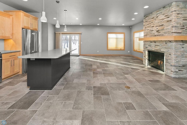 kitchen with light brown cabinetry, hanging light fixtures, a wealth of natural light, and a kitchen island