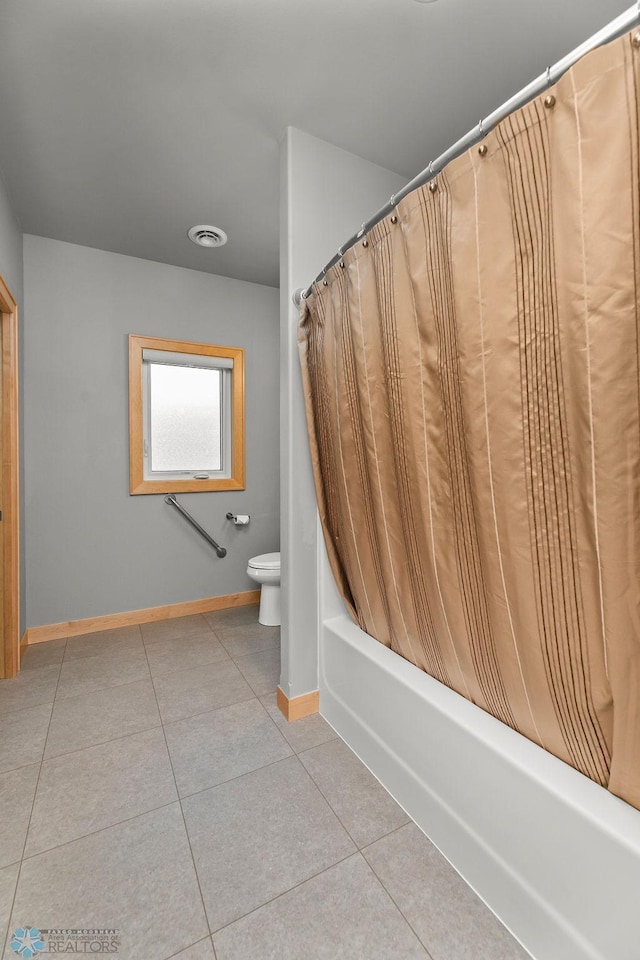 bathroom with shower / tub combo with curtain, toilet, and tile patterned flooring