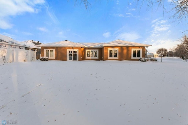 view of snow covered back of property