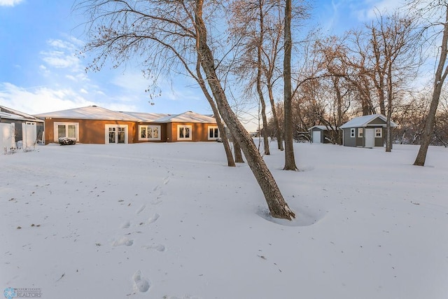 yard covered in snow with a storage shed