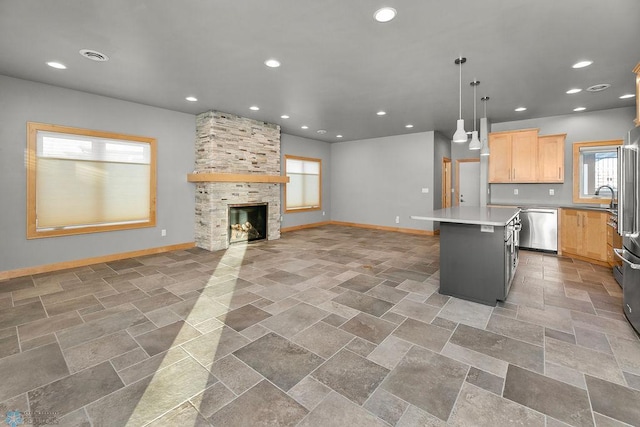 1336 Goldenwood Dr, West Fargo, ND 58078 - kitchen with appliances with stainless steel finishes, light brown cabinetry, baseboards, a center island, and recessed lighting