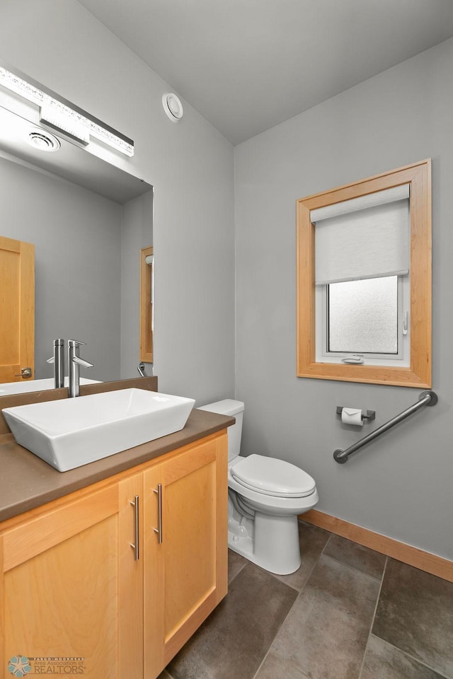 1336 Goldenwood Dr, West Fargo, ND 58078 - bathroom featuring vanity, toilet, and baseboards