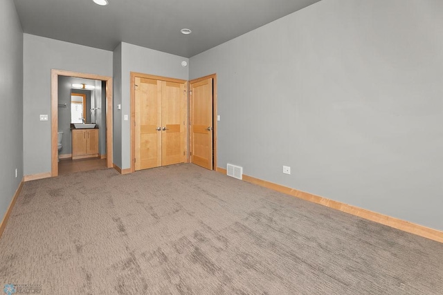 1336 Goldenwood Dr, West Fargo, ND 58078 - unfurnished bedroom with baseboards, carpet, connected bathroom, a closet, and a sink