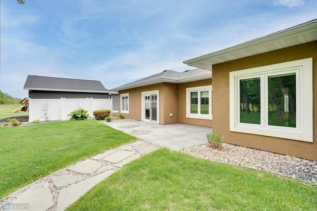 1336 Goldenwood Dr, West Fargo, ND 58078 - rear view of property with stucco siding, a patio area, and a yard
