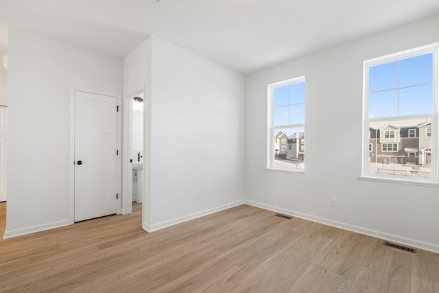 unfurnished room with a wealth of natural light and light wood-type flooring