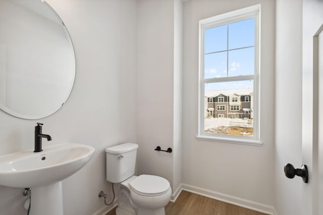 bathroom with wood-type flooring, toilet, and sink