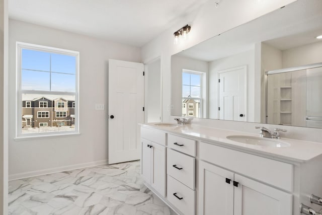 bathroom featuring a shower with door, vanity, and plenty of natural light