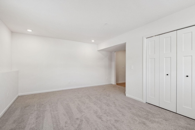 unfurnished bedroom featuring light carpet and a closet