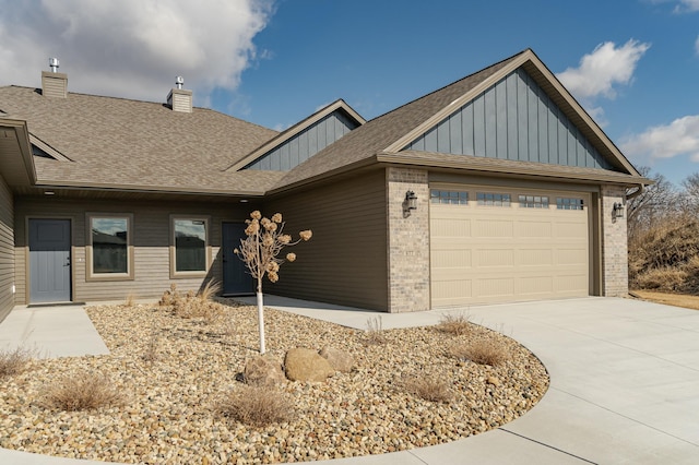 view of front of home featuring a garage, concrete driveway, a chimney, board and batten siding, and brick siding