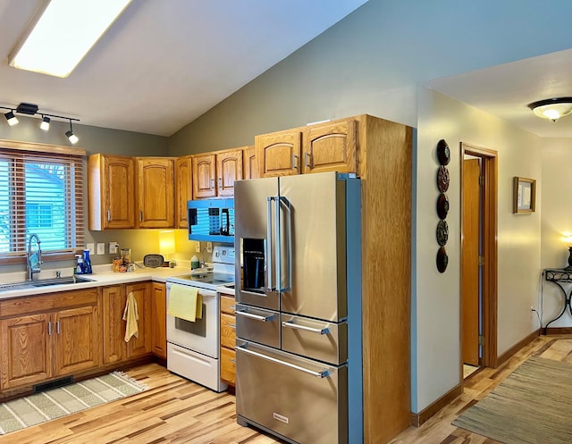 kitchen with lofted ceiling, sink, high end refrigerator, white electric stove, and light wood-type flooring