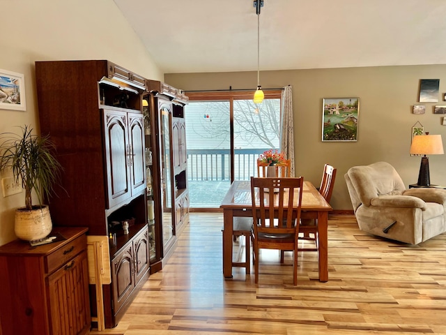 dining space featuring lofted ceiling and light hardwood / wood-style floors