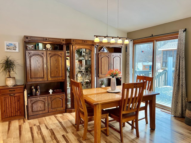 dining area featuring vaulted ceiling and light wood-type flooring