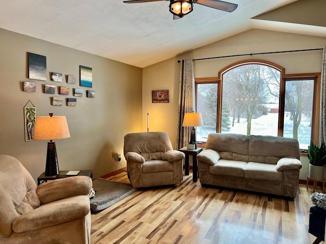 living room with ceiling fan, lofted ceiling, and light hardwood / wood-style flooring