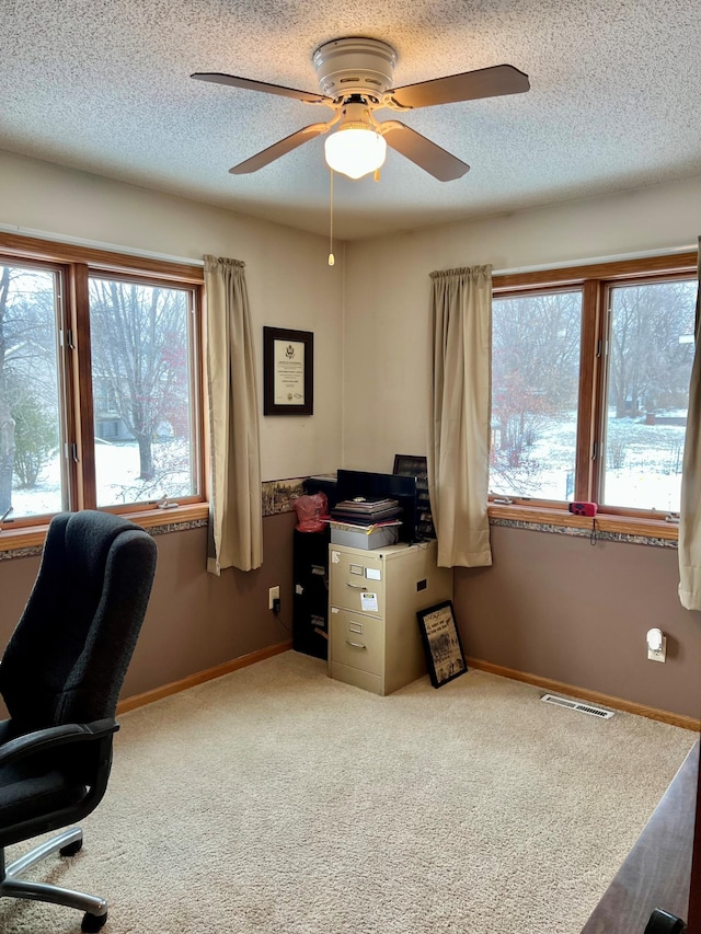 office area featuring ceiling fan, light carpet, and a textured ceiling