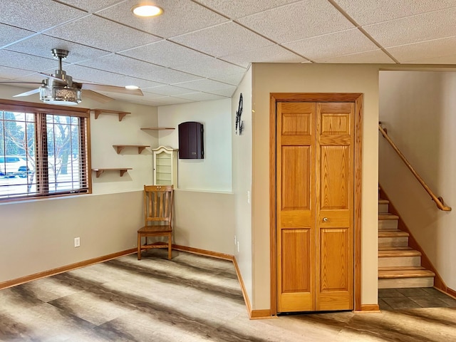 unfurnished room with ceiling fan, a paneled ceiling, and wood-type flooring