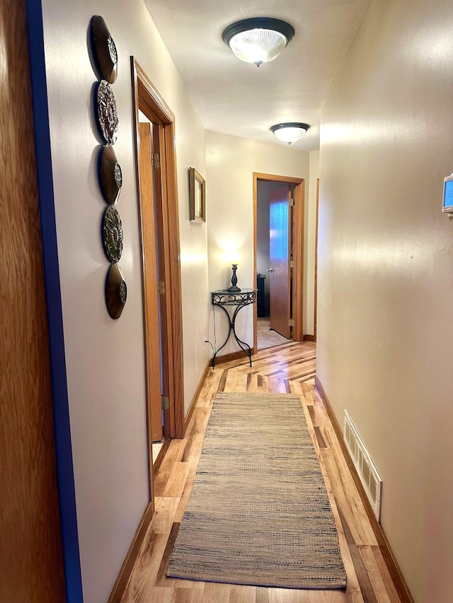 hallway with light hardwood / wood-style floors