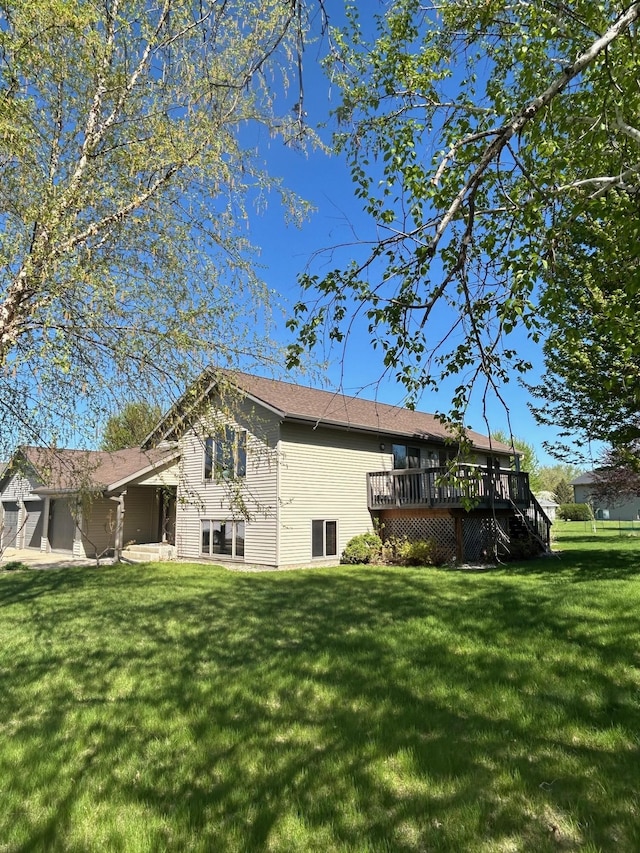 back of house featuring a wooden deck and a yard