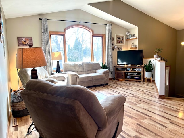 living area with vaulted ceiling and light wood-style floors