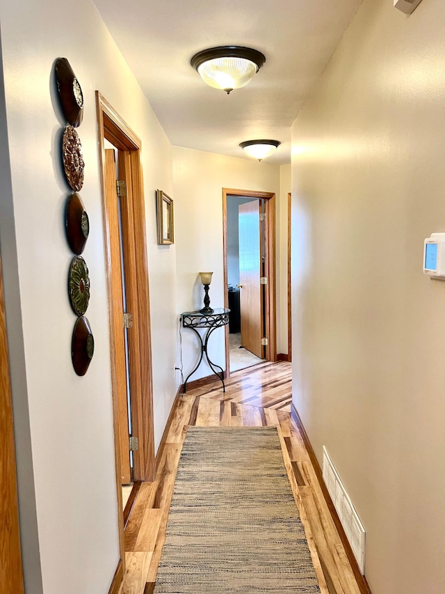 corridor with baseboards and parquet flooring