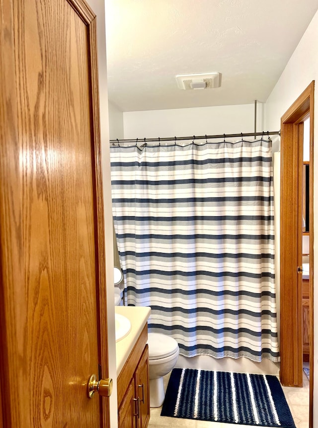 bathroom featuring toilet, vanity, and shower / bath combination with curtain