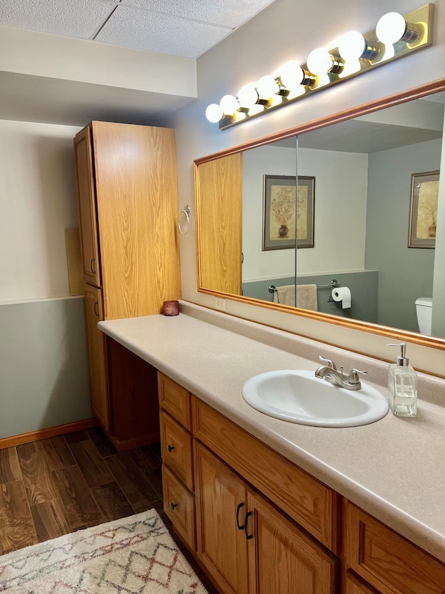 bathroom with wood finished floors, vanity, and toilet