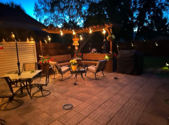 patio at twilight with outdoor dining area and fence