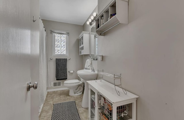 bathroom with sink, curtained shower, and toilet