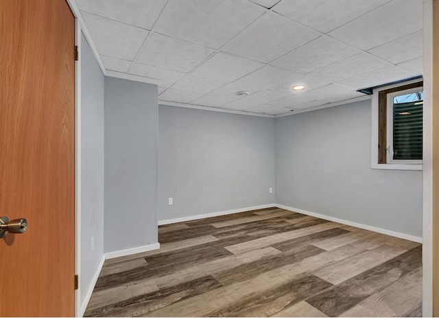 interior space with a drop ceiling and hardwood / wood-style flooring