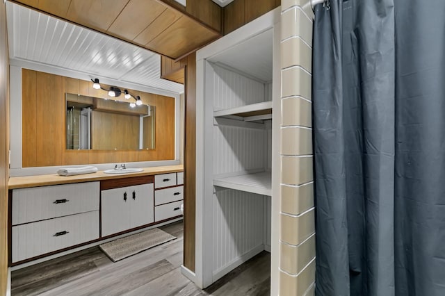 bathroom with vanity, wood walls, and hardwood / wood-style flooring