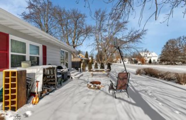 yard layered in snow with an outdoor fire pit